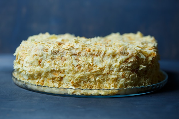 Hausgemachter Napoleon-Kuchen mit Sahne auf grauem Hintergrund.