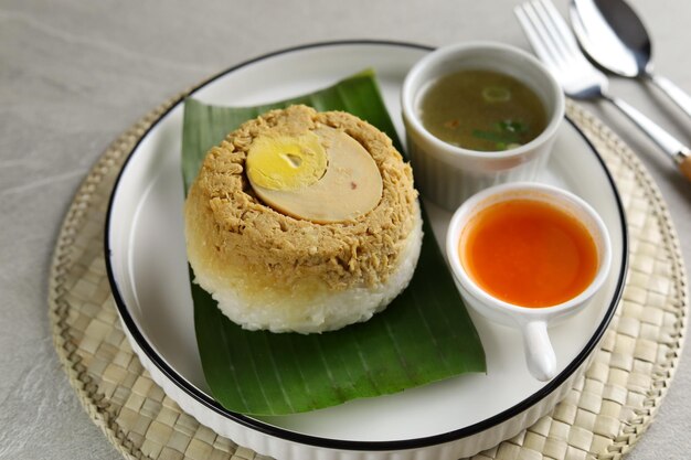 Hausgemachter Nasi Tim Ayam Gedämpfter Reis mit gewürfelter Hühnersojasauce und halbem Ei
