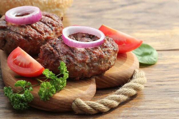 Foto hausgemachter rindfleischburger mit zwiebeln auf dem schneidbrett