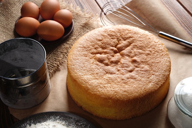 Hausgemachter runder Biskuitkuchen oder Chiffonkuchen auf Backpapier so weich und lecker mit Zutaten wie...