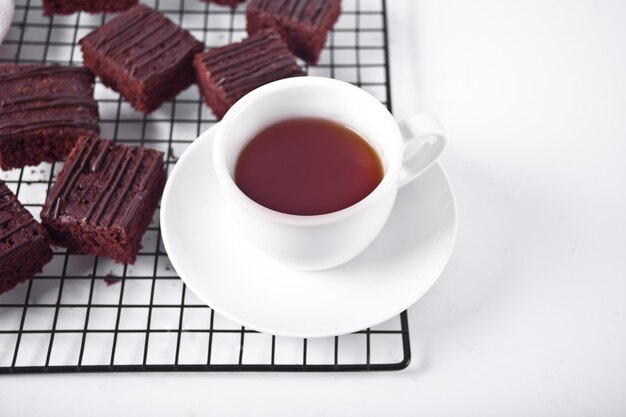 Hausgemachter Schokoladen-Brownie und eine Tasse Kaffee auf dem Träger