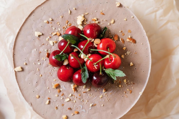 Hausgemachter Schokoladenkuchen mit Kirsche auf Pergamentpapier Lieferung von Lebensmitteln Hausgemachtes Backen Draufsicht Köstliche Torte mit Schokolade und Kirsche auf dem Holztisch in der Nähe