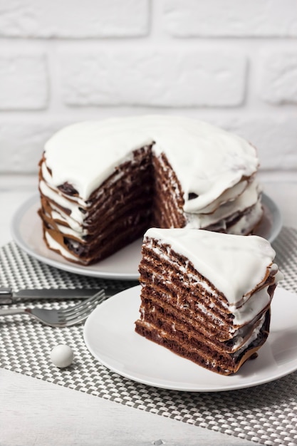 Hausgemachter Schokoladenkuchen mit Sahne. Stück Kuchen auf einem Teller