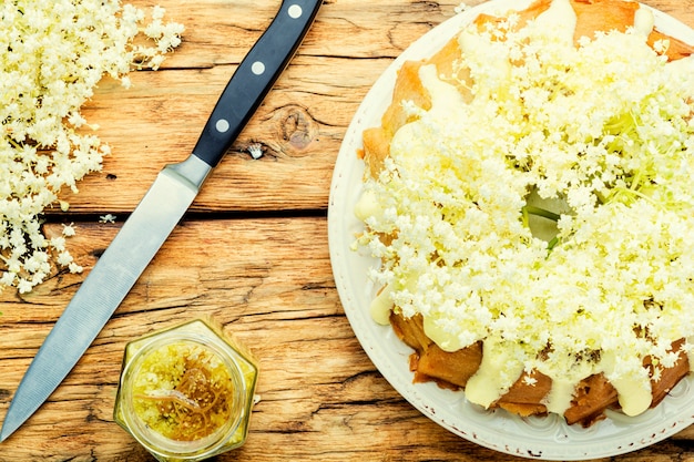 Hausgemachter Sommerkuchen garniert mit Holunderblüten. Süßer rustikaler Kuchen.