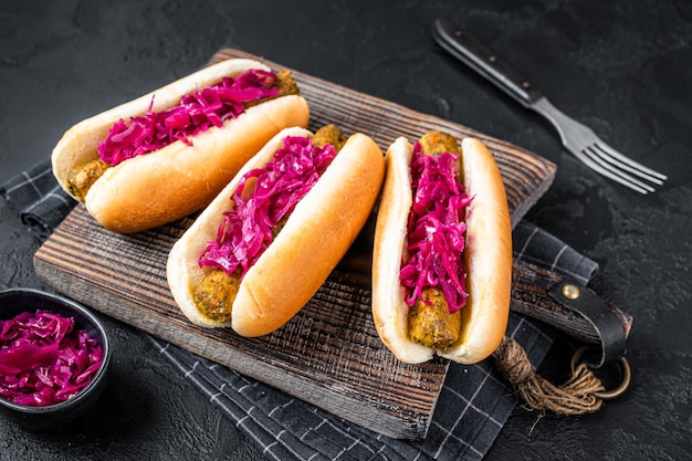 Hausgemachter veganer Hot-Dog mit fleischloser vegetarischer Wurst und Kohl. Schwarzer Hintergrund. Ansicht von oben.