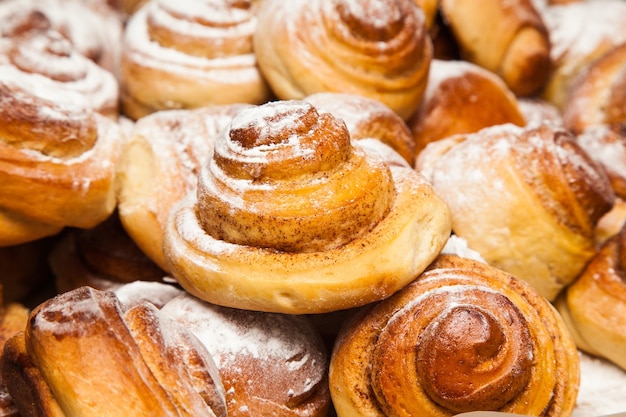 Hausgemachtes Backen. Gebackene Zimtschnecken, bestreut mit Puderzucker