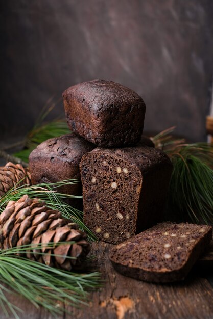 Hausgemachtes braunes fermentiertes Brot mit Zedernnüssen auf dunklem Holzhintergrund