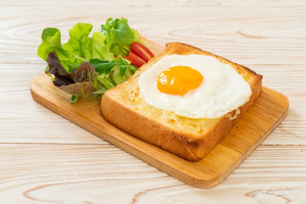 hausgemachtes Brot geröstet mit Käse und Spiegelei obenauf mit Gemüsesalat zum Frühstück