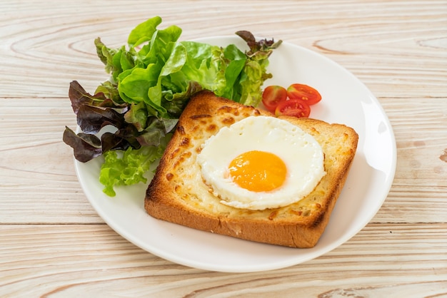 hausgemachtes Brot mit Käse und Spiegelei mit Gemüsesalat zum Frühstück geröstet