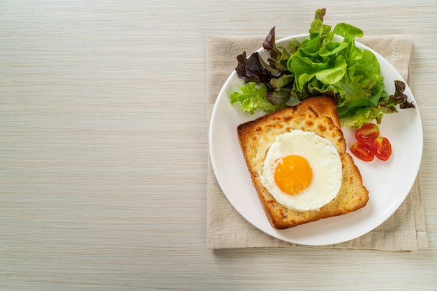 hausgemachtes Brot mit Käse und Spiegelei mit Gemüsesalat zum Frühstück geröstet