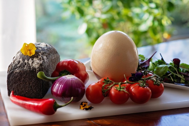 Hausgemachtes Brot, Straußenei und Gemüse, Paprika, Tomaten, Chili-Zwiebel-Salat, Zutaten für die Zubereitung eines Omeletts, Shakshuka, weicher, selektiver Fokus