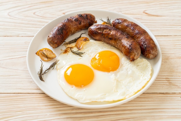 hausgemachtes doppeltes Spiegelei mit gebratener Schweinswurst - zum Frühstück