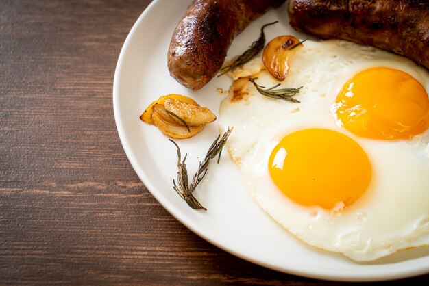 hausgemachtes doppeltes Spiegelei mit gebratener Schweinswurst - zum Frühstück