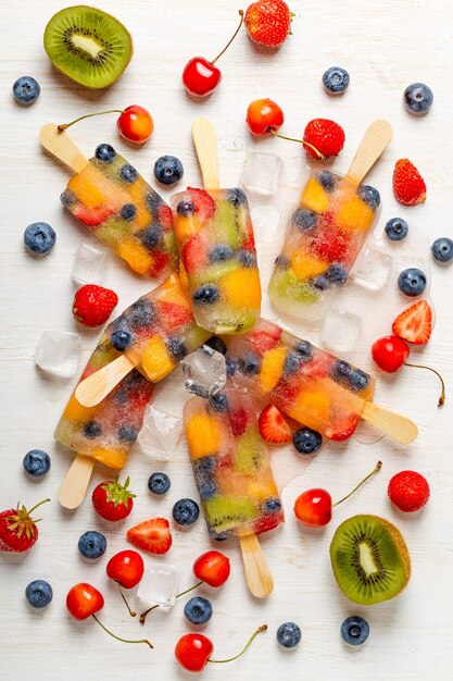 Hausgemachtes Eis am Stiel mit Beeren und Früchten