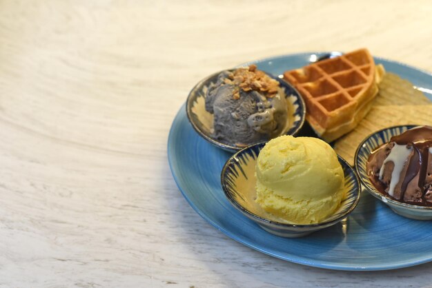 Hausgemachtes Eis mit Waffeln auf Teller mit Schokoladensirup