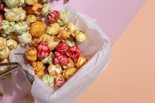 Hausgemachtes farbiges Popcorn auf farbigem Tisch mit kontrastreichem Licht. Snack-Konzept