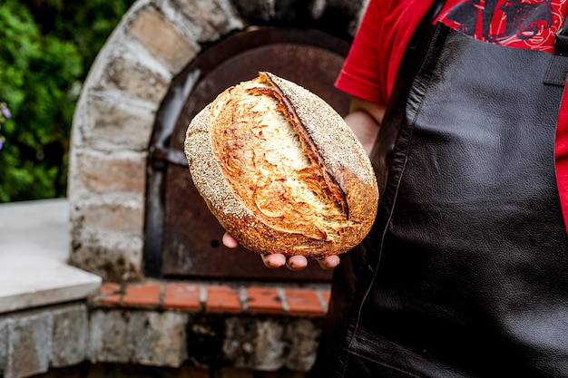 Hausgemachtes frisches Brot in der Hand des Bäckers