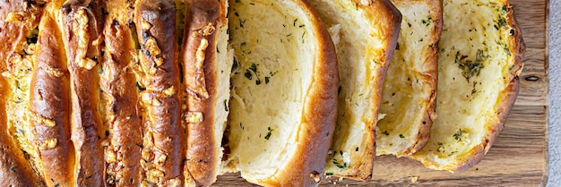 Hausgemachtes frisches Brot zum Auseinanderziehen mit Kräutern (Petersilie, Thymian, Rosmarin, Dill), Knoblauch, Käse