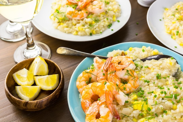 Hausgemachtes Maisrisotto mit gebratenen Garnelen auf dem Esstisch.