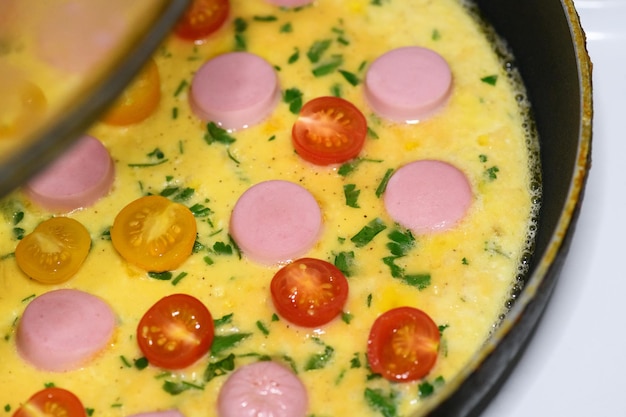 Foto hausgemachtes omelett mit wursttomaten und kräutern in der nähe