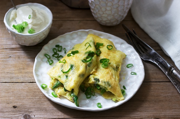 Hausgemachtes Omelettfrühstück mit Spargel und Zwiebeln und heißem Kaffee. Rustikaler Stil.