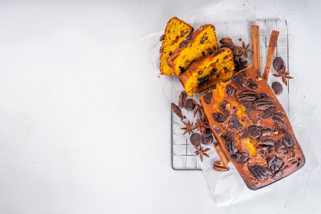 Hausgemachtes Pekannuss- und Schokoladen-Kürbisbrot. In Scheiben geschnittenes, süßes Dessert-Kürbisbrot mit Nüssen und Schokoladentropfen mit Zutaten, Draufsicht, Kopierraum