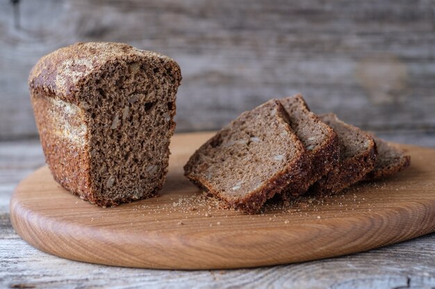 Hausgemachtes Roggen- und Weizenbrot mit Sonnenblumenkernen auf Eichenbrett