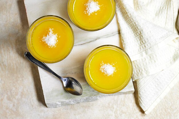 Foto hausgemachtes schichtförmiges veganes dessert aus gebackener kokosnusscreme und schokolade und orangenfruchtgelee auf marmor