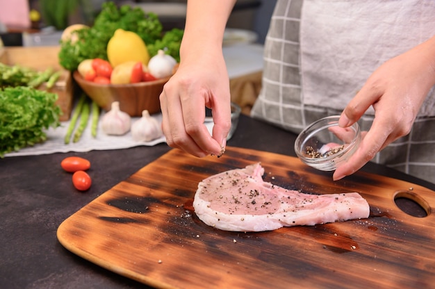 Foto hausgemachtes schweinekotelettsteak mit salat. online-lernen zum kochen von diät und gesundem essen, wenn sie während des coronavirus zu hause bleiben.