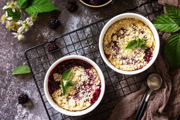 Hausgemachtes Sommerdessert Blackberry Crumble in Auflaufform auf einer Steinarbeitsplatte Draufsicht