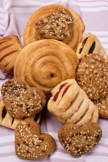 Hausgemachtes süßes Brötchen aus Blätterteig gefüllt mit Beerenmarmelade auf vertikaler rosa Serviette