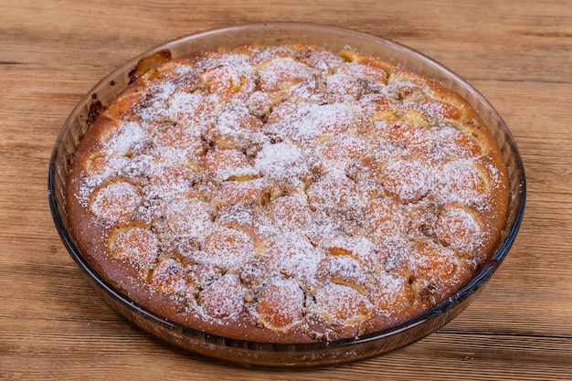 Hausgemachtes, verzehrfertiges Bio-Aprikosenkuchen-Dessert Aprikosentörtchen mit Walnuss auf hölzernem Hintergrund aus nächster Nähe