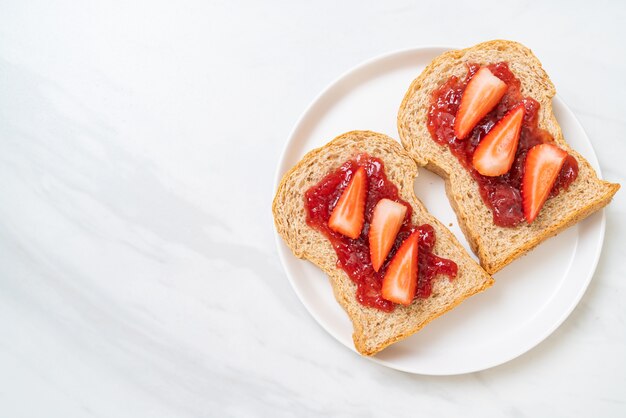 hausgemachtes Vollkornbrot mit Erdbeermarmelade und frischer Erdbeere