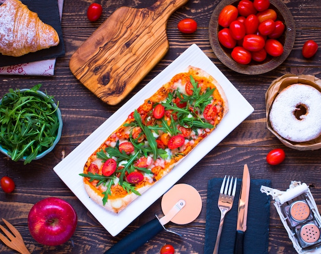 Hausmädchen frische Pizza mit Tomaten, Rucola und Mozzarell