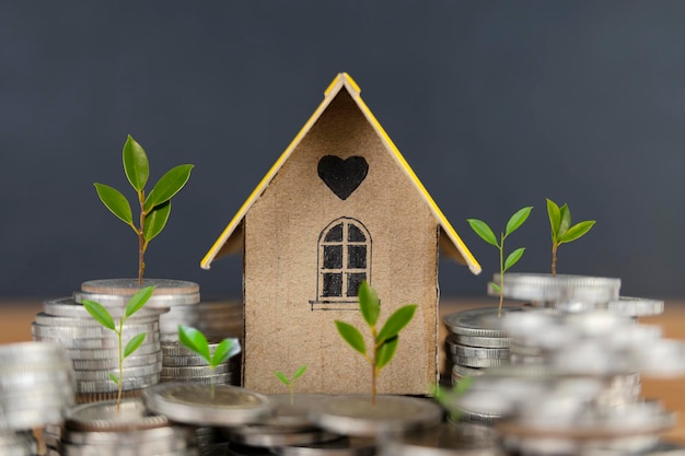 Hausmodell auf den Münzen, die für Konzeptinvestitionshypothekenfondsfinanzierung und Zinsheimdarlehen sparen