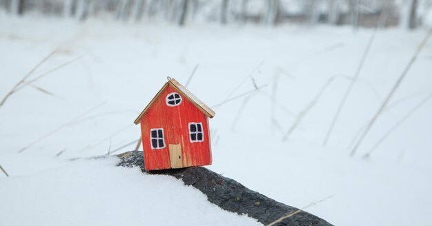 Hausmodell auf Schnee-Hintergrund im Winter