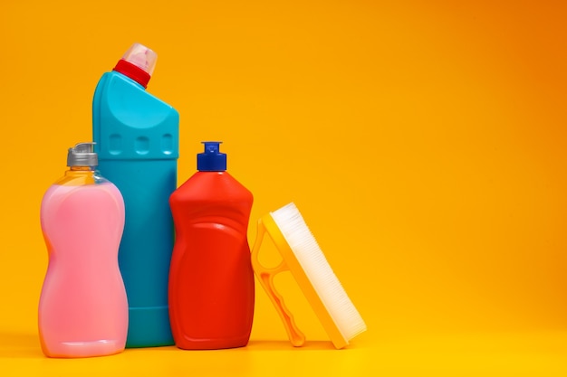 Hausreinigungsmittelflaschen auf gelbem Hintergrund