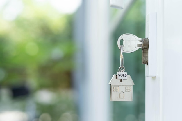 Hausschlüssel am Schlüsselloch Das Haus wird verkauft Eigentumskonzept