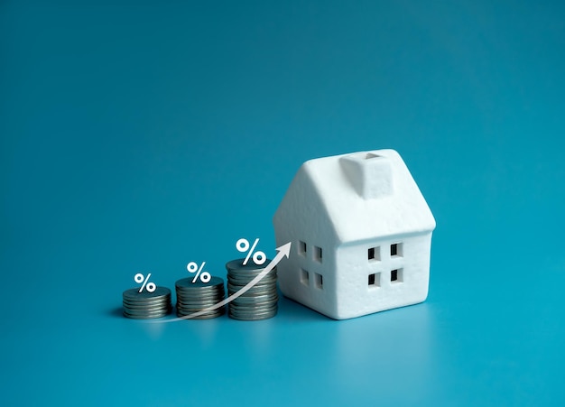 Haussteuerkonzept Wohn- oder Immobiliengrundstücke und Gebäude jährliche Besteuerung Pfeil nach oben und Prozentsymbol auf dem Münzstapel als Diagrammschritt und weißes kleines Hausmodell auf blauem Hintergrund