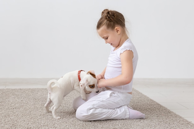 Haustiere und Tierkonzept - Kindermädchen, das mit Welpen Jack Russell Terrier spielt