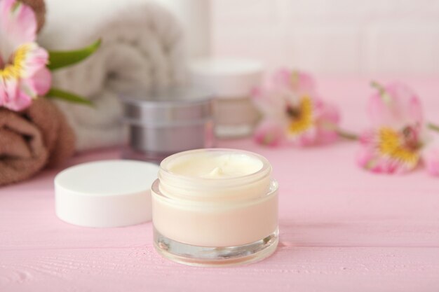 Hautpflegecreme und Blumen auf dem Tisch Kosmetik für die Hautpflege