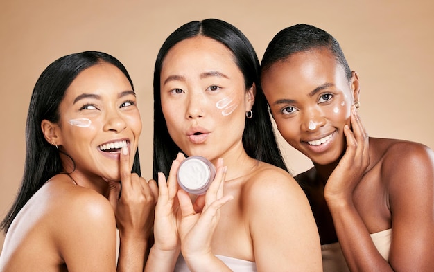 Hautpflegeporträt und Vielfalt von Freunden mit Gesichtscremeprodukt im Studio für Wellness auf braunem Hintergrund Gesichtsmodell und Lotion von Frauen für Schönheit anders und Gesichtshaut und Freude isoliert