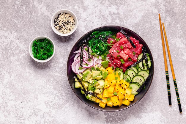 Hawaiianische Thunfisch-Poke-Schüssel mit Algen-Avocado-Mango-Gurken-Draufsicht