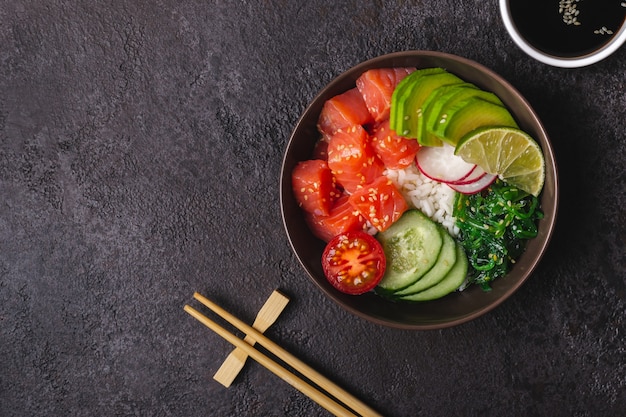 Hawaiianischer Lachs-Poke-Salat mit Reis, Gemüse und Algen, serviert in einer Schüssel.