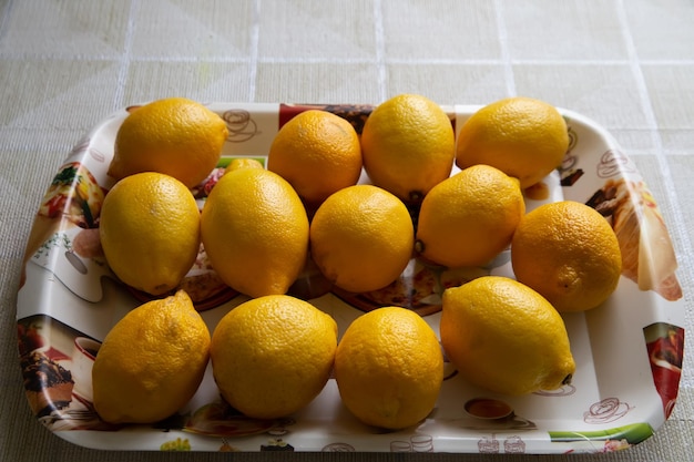 Hay una bandeja de limones en la mesa.