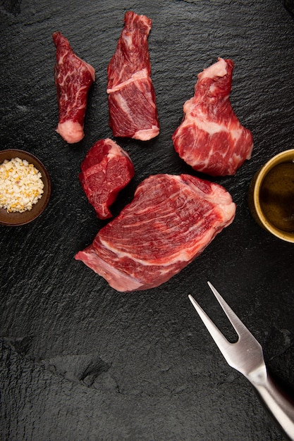 Hay capas de carne cruda en la tabla de cortar negra Hay sal y pimienta