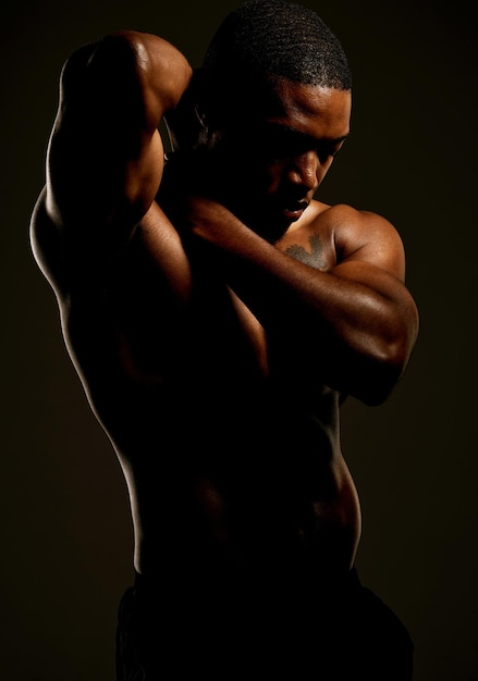 Hay un hombre sensible debajo de todo ese músculo Foto de estudio de un joven en forma posando sobre un fondo negro