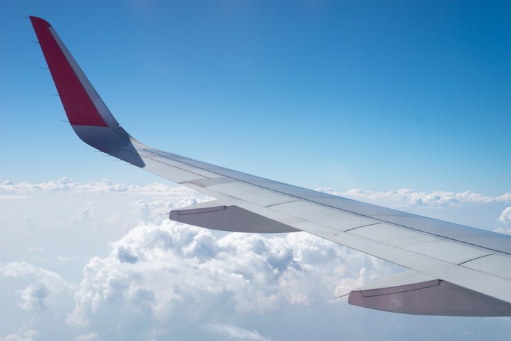 Hay muchas nubes blancas entre el cielo azul. Esta vista es desde la ventana del avión.