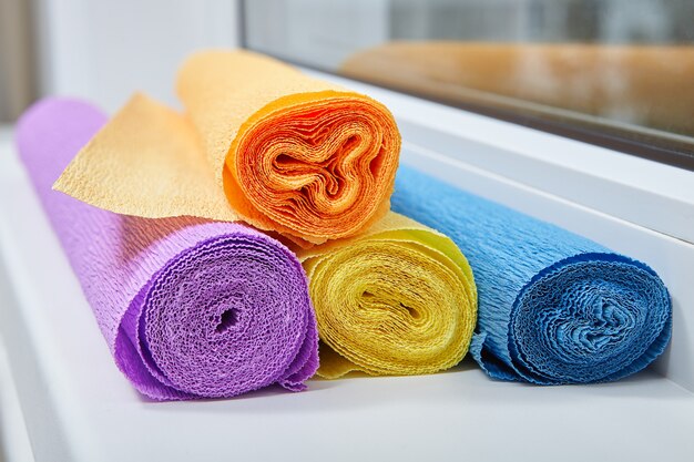 Hay rollos de papel de colores arrugado en el alféizar de la ventana.