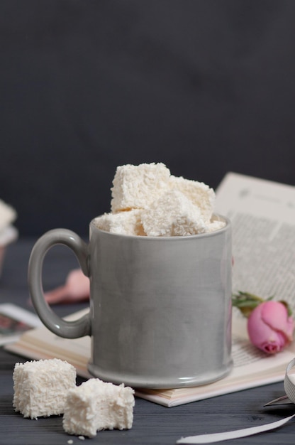 Hay una taza en la mesa llena de dulces hechos a mano.